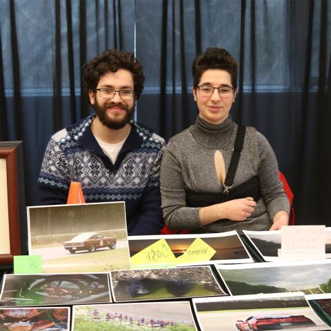 Two students sitting at table with photography.